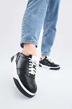Black leather sneakers on a white platform  4205590 photo №1